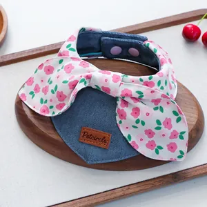 Floral bow denim pet bandana with snap buttons for cats and dogs on wooden tray