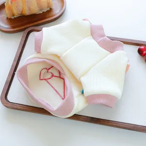 Niedliches Haustier-Shirt Detail in Rosa und Creme mit weichem Rippstoff und rotem Herz.