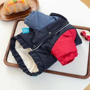 Detail of warm pet coat with fleece lining and colorful patchwork on a wooden tray
