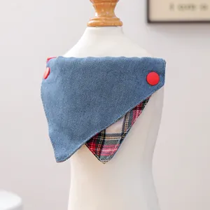 Detail van denim bandana voor huisdieren met rode knopen en geruite binnenvoering