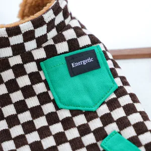 Dettaglio del gilet per cani con velluto a coste a scacchi marroni e tasca verde