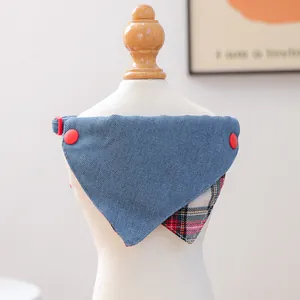 Detail van omkeerbare blauwe denim hondensjaal met rode drukknopen en ruitvoering