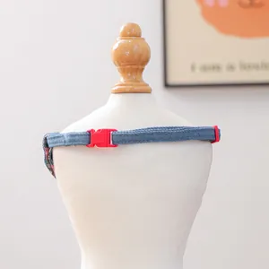 Detail van blauwe denim bandana voor huisdieren met een stevige rode plastic gespsluiting