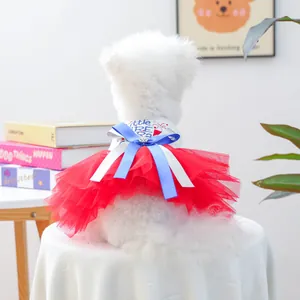 Detail of Little Firecracker pet dress with red mesh skirt and bow on a white dog