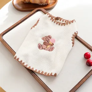 Nahaufnahme der Haustier-Strickweste mit Bären-Stickerei und braunen Häkelkanten-Details