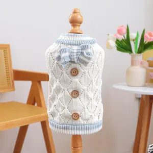 Cream knit pet sweater with blue striped trim and decorative bow on a mannequin