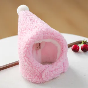 Detailed view of pink fleece pet hat with white pompom and adjustable velcro strap