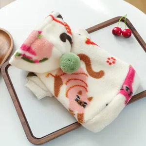 Detail of soft fleece pet hoodie with pink cartoon cat patterns and plush pom-pom