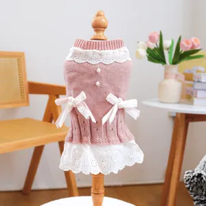 Nahaufnahme von rosa Strickkleid für Hunde mit weißem Saum und Perlenknöpfen