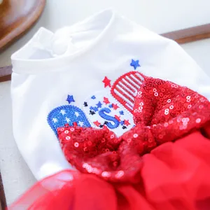 Close-up of pet dress with a large red sequin bow and USA star-themed embroidery detail