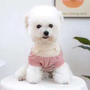 Close-up of pink knit dog sweater showing thick cable patterns and turtleneck detail