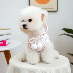 Detail of floral pet vest with soft fleece texture and cute white pompom drawstrings