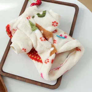 Detail of warm plush pet vest with red strawberry patterns and snap buttons