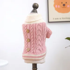 Detailed close-up of pink and cream knitted pet sweater with cable stitch and wood buttons