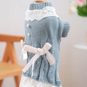 Detail eines warmen graublauen Strickkleides für Haustiere mit Spitze und Schleife