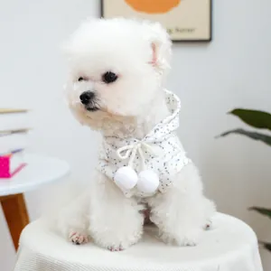 Detail of floral pet hoodie featuring soft fabric and white plush pom-pom drawstrings