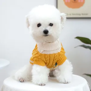 Detalle de suéter de punto trenzado amarillo jengibre con cuello alto para perro