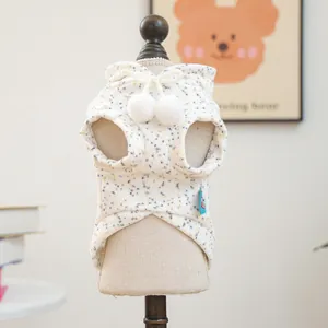 Detail of white knit pet hoodie featuring colorful specks and decorative soft pompoms