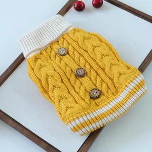 Detalle del suéter de punto amarillo para mascotas con trenzado y botones de madera