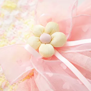 Close-up detail of cute pink pet tutu dress with multi-layer mesh and fabric flower.