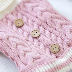 Close-up of pink cable knit pet sweater with decorative wooden buttons and ribbed edges