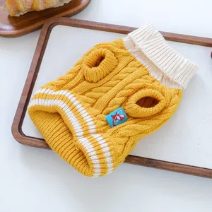 Detalle de suéter para mascotas de punto trenzado amarillo con cuello alto cálido