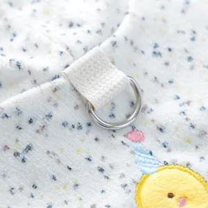 Macro detail of silver D-ring and cute chick embroidery on spotted plush pet hoodie