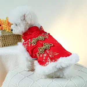 Vue détaillée d'un costume festif rouge pour chien avec broderie dorée et fourrure blanche