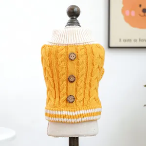 Detalle de jersey amarillo de punto de ochos para mascotas con cuello alto y botones de madera