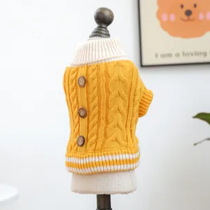 Detalle de jersey amarillo para mascotas con tejido de ochos y botones decorativos de madera