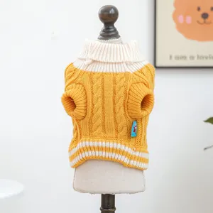 Detalle del suéter amarillo de punto de ochos para perro con cuello y dobladillo blanco suave