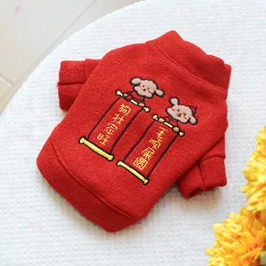 Detail of red pet festive sweater featuring intricate cartoon embroidery and plush texture