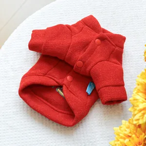 Close-up of red winter pet jacket featuring embroidery and brand woven label details