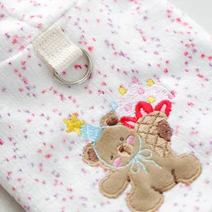 Close-up of white fleece dog hoodie featuring cute bear embroidery and metal D-ring attachment