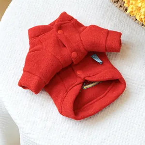 Detail view of red pet winter coat showing warm wool texture and snap button closure