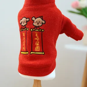Close-up of red pet sweater featuring detailed cartoon dog embroidery and festive text