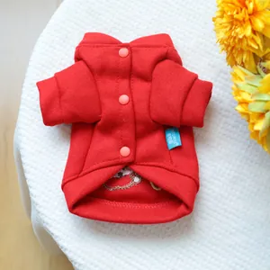 Detail of red fleece pet sweater with orange buttons and embroidered lining for winter
