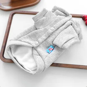 Detalle de sudadera gris para mascotas con forro polar blanco y botones de presión