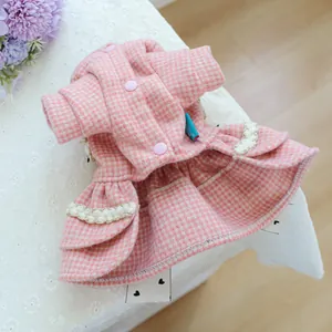 Détail d'une robe rose à carreaux pour animaux avec dentelle blanche et boutons