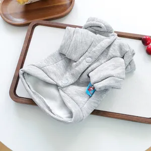 Detail of warm pet vest with white fleece lining and snap buttons on a tray