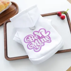 Detalle de sudadera blanca para mascota con bordado 'Be Mine' y anillo en D para correa