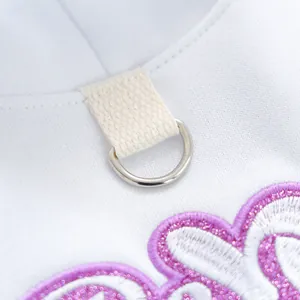 Detalle del anillo en D metálico y bordado de purpurina púrpura en la sudadera para perro pequeño