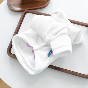 Detalle de sudadera blanca para mascotas con botones a presión y algodón suave