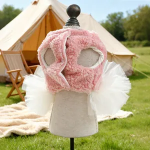 Detail of pink sherpa pet vest with lace trim shown in a cozy outdoor camping setting