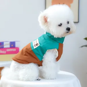 Dettaglio del caldo gilet per animali con design patchwork verde smeraldo e marrone caramello