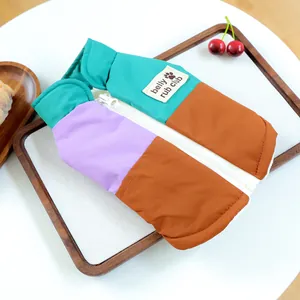 Dettaglio del gilet color-block per animali con zip e etichetta Belly Rub Club tessuta