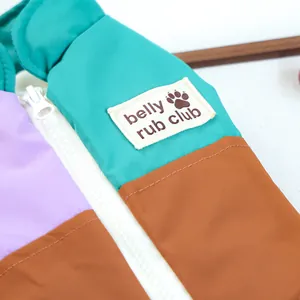 Dettaglio ravvicinato della cerniera e dell'etichetta tessuta sul gilet colorato per cani