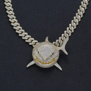 Macro detail of gold shark pendant with zircon stones on a thick cuban link chain