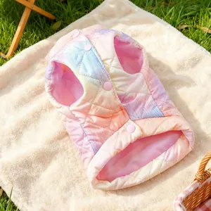 Detailaufnahme der gesteppten Regenbogen-Haustierweste mit rosa Knöpfen auf Plüschteppich
