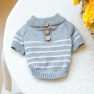 Detail of gray striped pet sweater featuring wooden buttons and soft ribbed knit texture